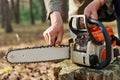 Faceless logger preparing chainsaw for work, cheking saw for faults, unknown logger forester with professional tool for cutting