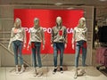 Faceless mannequins in hooded sweatshirt and jeans stand against the background of the inscription and with tags `Sale` Royalty Free Stock Photo