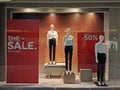 Faceless mannequins in white T-shirts and black jeans stand next to the inscription `The Sale` and `Discounts up to 50 %` Royalty Free Stock Photo