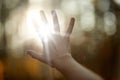 Faceless picture, man`s hand covering sunlight,l sun shiing through hand, image of human`s hand covering sun, bright rays of sun Royalty Free Stock Photo