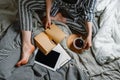 Faceless portait of woman sitting in her bed with tablet and tea