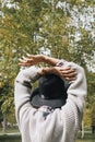 Faceless portrait from the back of young female in sweater and hat