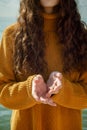 Faceless portrait of woman on a beach stretching forward out her hands