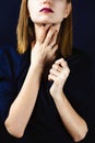 Faceless portrait of young adult white woman holding her hands with dark manicure on her neck Royalty Free Stock Photo