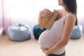 Faceless pregnant woman with equipment holds pilates equipment in the hall with chair bags. Unrecognizable Expectant Royalty Free Stock Photo