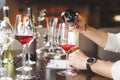 Faceless sommelier pours red wine into stem glass. Royalty Free Stock Photo