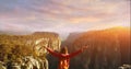 Tourist woman standing on cliff, enjoying view on canyon with beautiful sunset sky