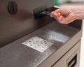 Faceless woman inserts bank card at ATM.
