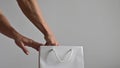 A faceless woman puts a black dildo in a white paper bag. Clitoral vaginal vibrator for masturbation. The seller packs