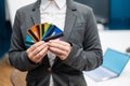 A faceless woman in a suit holds several multi-colored credit cards. A bank employee shows a lot of different plastic Royalty Free Stock Photo