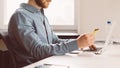 Faceless young man with credit card in hand shopping online on laptop