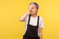 Facepalm. Portrait of forgetful hipster girl holding hand on forehead. yellow background, studio shot