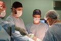 The faces of doctors surgeons in masks are a big plan, an operating room, a surgeon performs an operation in a modern Royalty Free Stock Photo