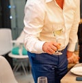 Without faces. a man holds a glass of champagne in his hand.