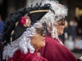 Faces of two adult women in hats, wigs and masks taken in profile at the carnival in Venice, Italy Royalty Free Stock Photo