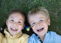 faces of two laughing happy children, boy and girl of 6-7 years old in yellow and blue t-shirts Royalty Free Stock Photo
