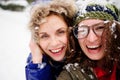 Faces of two young women are closed up with snow.