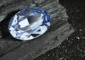 Faceted blue jewelry gemstone sapphire on black coal background Royalty Free Stock Photo