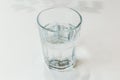 Faceted glass with drink water on a white table Royalty Free Stock Photo