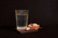 Faceted glass of vodka, sandwich with rye bread, herring, ham, clove of garlic