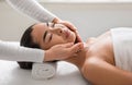 Facial beauty treatment. Asian woman getting face lifting massage at cosmetology cabinet Royalty Free Stock Photo