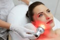 Facial Beauty Treatment. Woman Doing Red Led Light Therapy Royalty Free Stock Photo