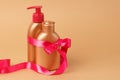 Facial, body skin care on beach, sea on summer vacation. Set for safe tan with pink satin ribbon on bronze background. Copy space