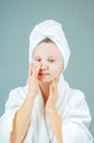 Facial care and beauty treatments. Beautiful woman with a sheet moisturizing mask on her face Royalty Free Stock Photo