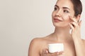 Facial Care. Female Applying Cream and Smiling. Portrait Of  Young Woman With Cosmetic Cream On Skin. Closeup Of Beautiful Girl Wi Royalty Free Stock Photo