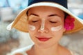 Facial Care. Female Applying Sun Cream and Smiling. Beauty Face. Portrait Of Young Woman Smear Moisturizing Lotion on Skin Royalty Free Stock Photo