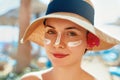 Facial Care. Female Applying Sun Cream and Smiling. Beauty Face. Portrait Of Young Woman Smear Moisturizing Lotion on Skin. Royalty Free Stock Photo