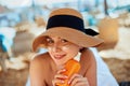 Facial Care. Young Female Holding Bottle Sun Cream and Applying on Face Smiling. Beauty Face. Royalty Free Stock Photo