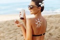 Facial Care. Young  Female Holding Bottle Sun Cream and  Applying on Face Smiling. Beauty Face.  Portrait Of Young Woman in hat Sm Royalty Free Stock Photo