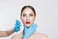 Facial cosmetic plastic surgery. Doctor surgeon hand in glove draw wrinkle lines on Woman face isolated white background.