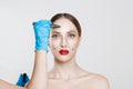 Facial cosmetic plastic surgery. Doctor surgeon hand in glove draw wrinkle lines on Woman face isolated white background.