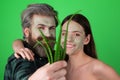 Facial green mask for fun couple. Funny couple getting facial care with aloe vera. Beautician is making facial mask on