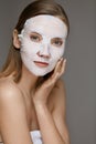 Facial mask. Woman using sheet mask on face skin for spa care Royalty Free Stock Photo