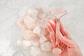 facial massage device.gua sha roller made of pink natural stone. Rose quartz Massage roller close-up in a womans hand on Royalty Free Stock Photo