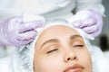 Facial skin care and protection. A young woman at a beauticians appointment. The specialist cleans the skin before