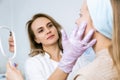 Facial skin care and protection. A young woman at a beauticians appointment. A specialist examines the face and skin