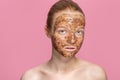 Facial skin scrub Coffee grounds mask on the face of a beautiful young woman Organic natural cosmetology Pink studio