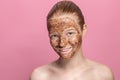 Facial skin scrub Coffee grounds mask on the face of a beautiful young woman Organic natural cosmetology Pink studio