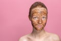 Facial skin scrub Coffee grounds mask on the face of a beautiful young woman Organic natural cosmetology Pink studio