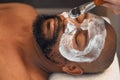 Facial, skincare and relax with black man in spa for beauty, luxury and mud mask. Wellness, therapy and health with male Royalty Free Stock Photo