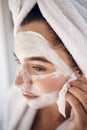 Facial, skincare and woman peeling a face mask for beauty in a grooming treatment with dermatology products. Relaxed