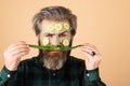Facial treatment. Funny bearded man with clay facial mask in beauty spa. Fun guy with facial mask with Cucumber and aloe