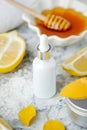 Facial treatment preparation. Simple homemade facial mask and spa products, honey, lemon and bottle with dropper on marble plate,