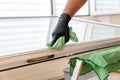 Facility management cleaner cleaning a window and window frame with green micro fiber cloths