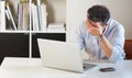 Facing the approaching deadline. a tired-looking businessman sitting in front of his laptop.