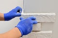 Facing wall decorative tiles, workers in blue glove Royalty Free Stock Photo